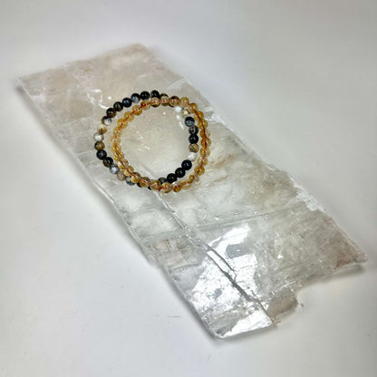 Armbånd med farverige perler placeret på en Mexicansk selenit plade rå.