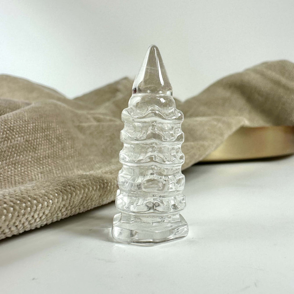 Bjergkrystal tempel med spirform står på beige baggrund.