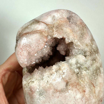 Pink Ametyst unika med delikat rosa nuance og naturlig hulning fyldt med glitrende krystaller. Den sjældne sten udstråler ro og kærlighed, ideel til hjertechakraet og følelsesmæssig heling. Dannet over millioner af år i Sydamerika, er hver sten unik og eftertragtet. Perfekt til meditation, dekoration eller som spirituel støtte i hjemmet eller personligt brug.