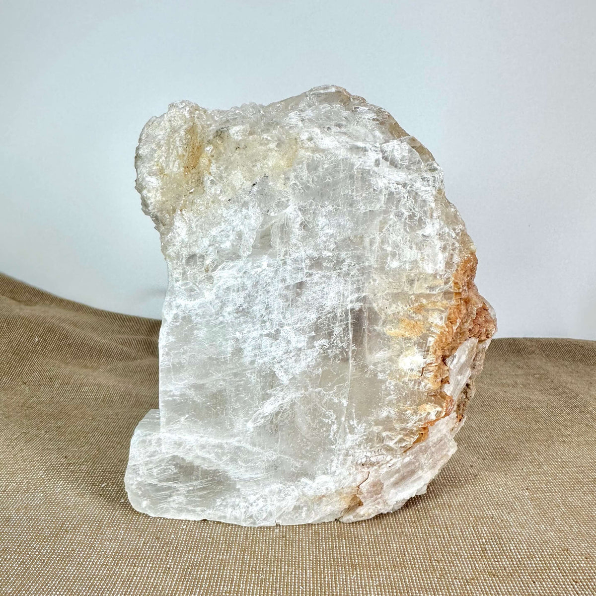 Mexicansk Selenit lampe nr. 7 er en håndlavet krystallampe skåret af naturlig selenit fra Mexico. Den har en organisk, rå form med gennemsigtig til hvid farve og naturlige strukturer. Lampen står på en lys brun overflade og har varme jordtoner i kanterne. Dens unikke krystalstruktur gør den ideel som beroligende belysning i hjemmet, perfekt til meditation, ro og velvære.