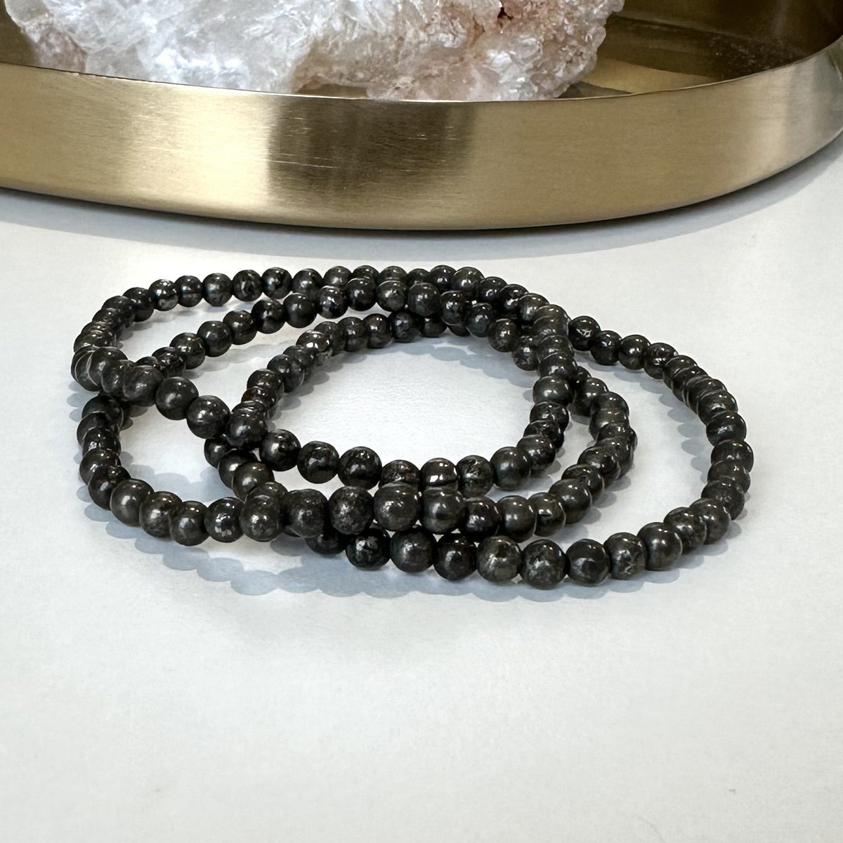 Sort Pyrit armbånd foran en bakke med krystaller.