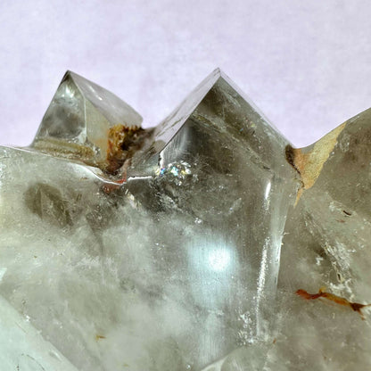 Nærbillede af en Røgkvarts klynge XXL med tydelige, naturlige krystalformationer i brunlige og grålige nuancer. Krystallens overflade fremstår rå og ubehandlet med synlige mineralforekomster og lyse reflekterende flader. Den kraftfulde sten forbindes med spirituel beskyttelse, rensning af negativ energi og styrkelse af jordforbindelse via rodchakraet. Ideel til både dekoration og meditation.