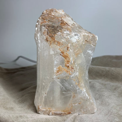 Mexicansk Selenit lampe nr. 22 med struktureret overflade i beige og brune nuancer på en beige klud.