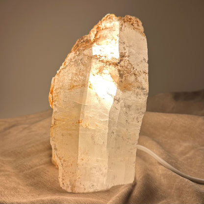 Mexicansk Selenit lampe nr 22 oplyst på en beige dug, viser dens tekstur og naturlige farver.