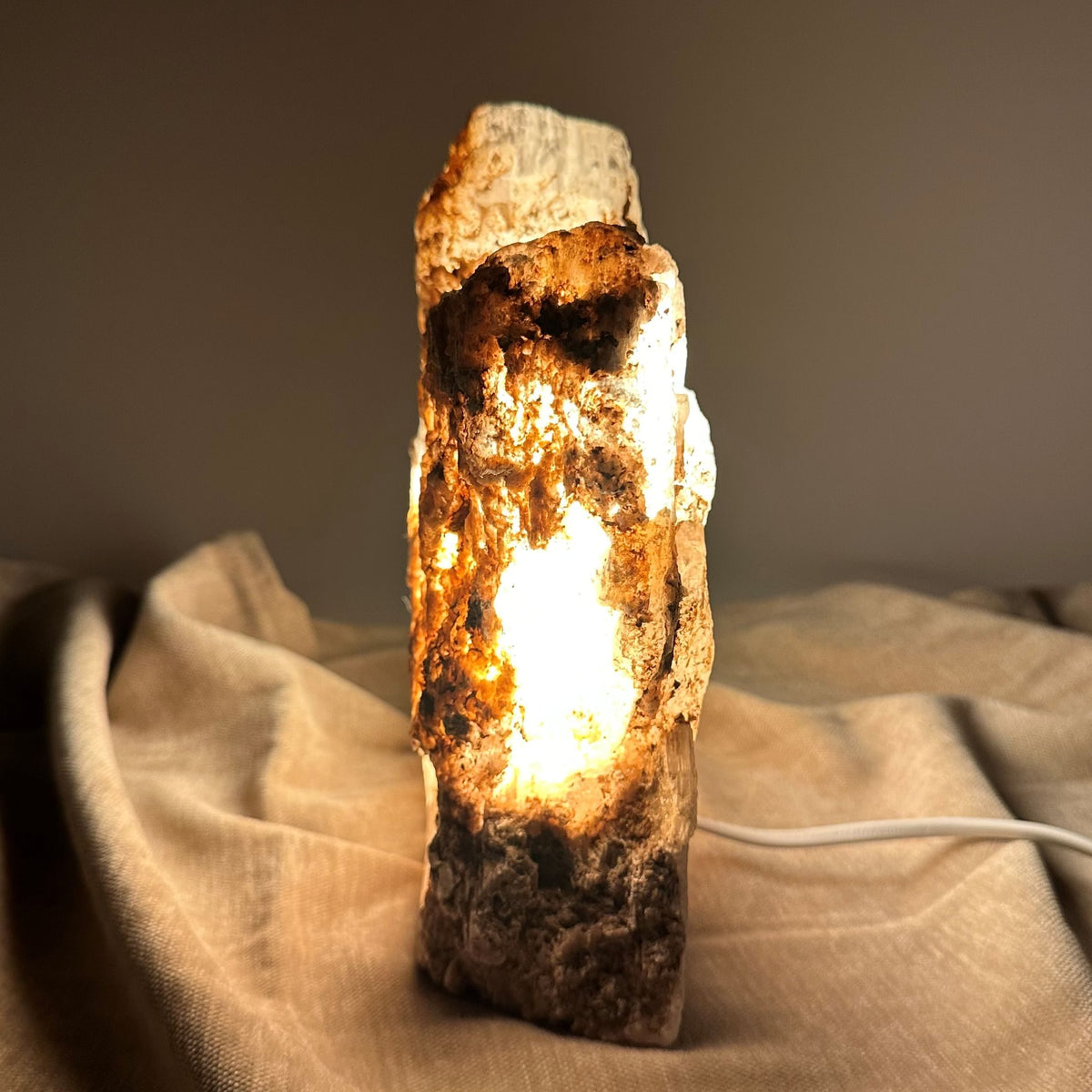 Mexicansk Selenit lampe nr 51 lyser op på en beige klud med varm glød.