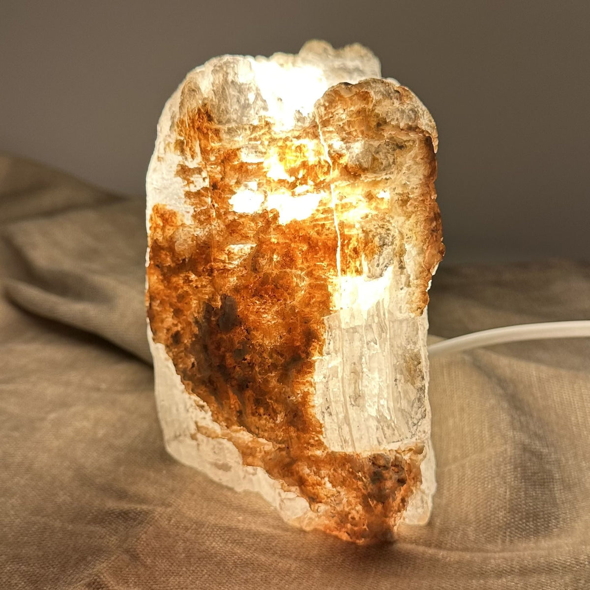 Mexicansk Selenit lampe nr. 42 med gyldent lys og rustik tekstur, stående på en beige overflade.