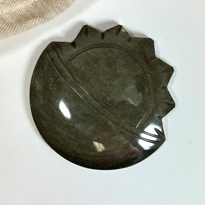 Guld Obsidian sol og måne skulptur med poleret overflade på hvid baggrund.