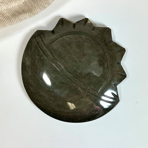 Guld Obsidian sol og måne skulptur med poleret overflade på hvid baggrund.