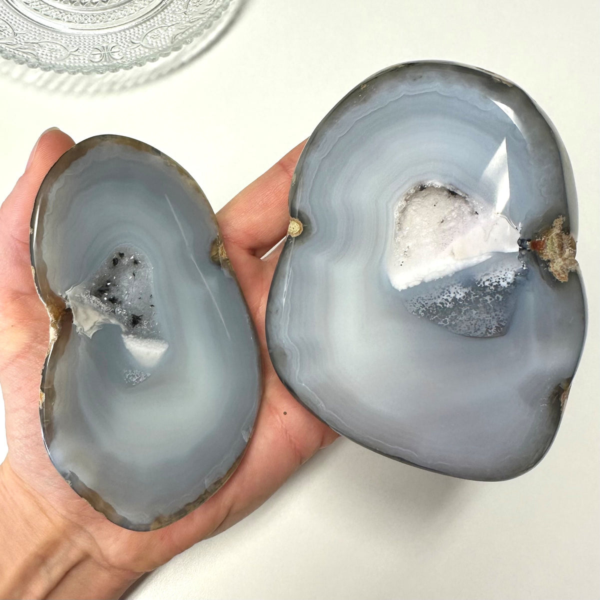 Person holder agat natur geode sæt i hånden, viser indre krystaller.