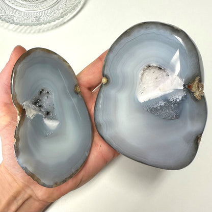 Person holder agat natur geode sæt i hånden, viser indre krystaller.
