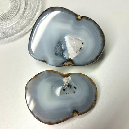 Agat natur geode sæt med to halve, blålige skiver med krystalstruktur på hvid baggrund.