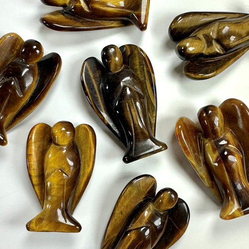 Tigerøje engel figurer arrangeret på en hvid overflade. Shiny brune nuancer skaber en varm og rolig atmosfære.