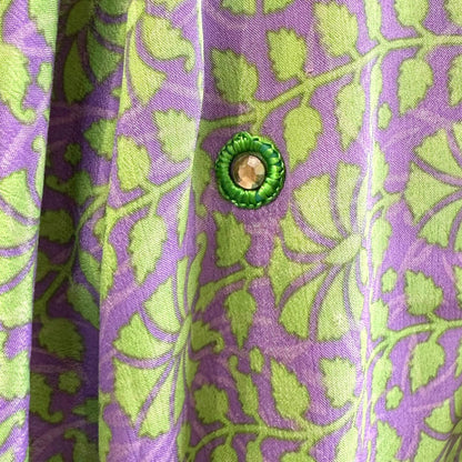 Dekorativt mønster på lilla og grøn kimono med rund knap.