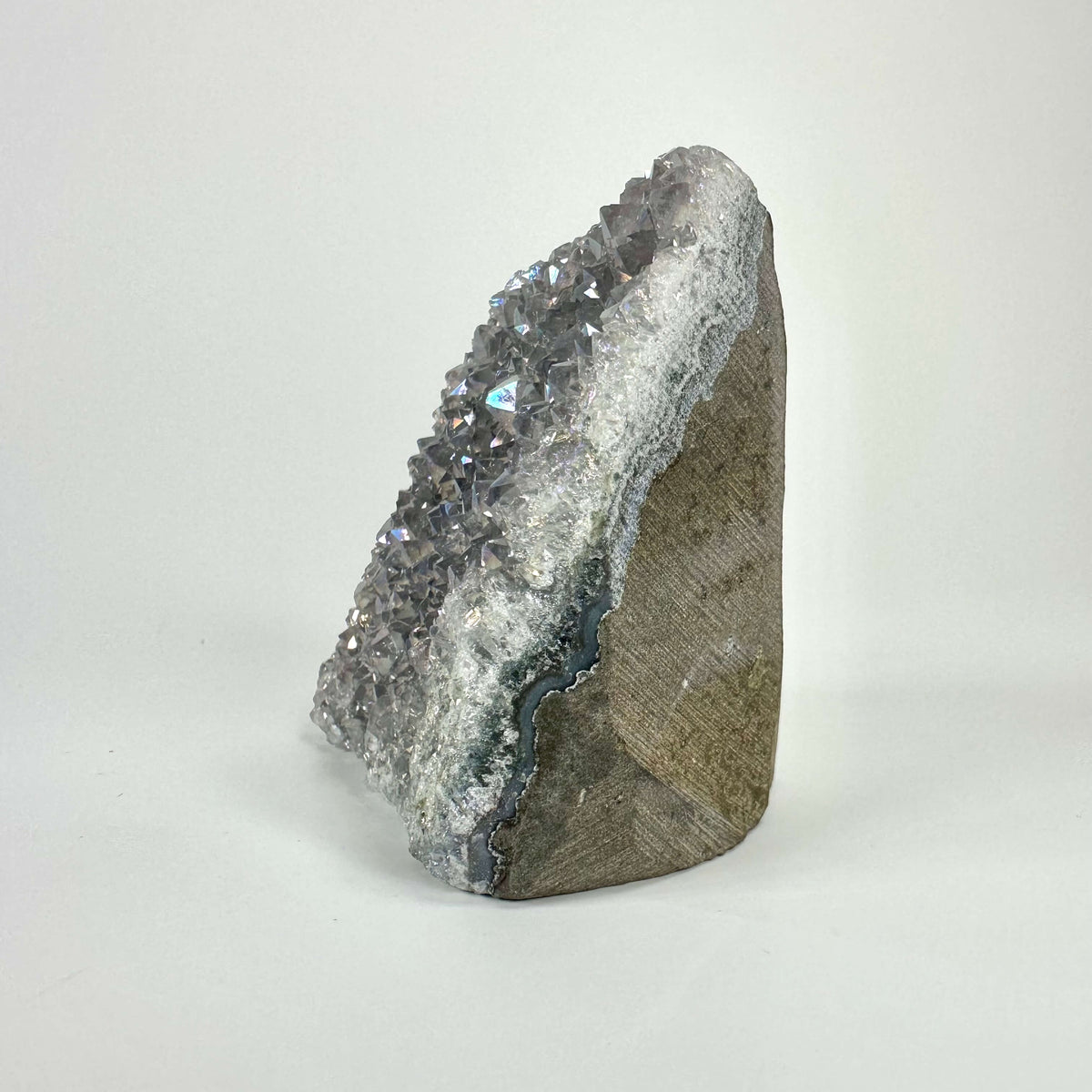 Ametyst aura geode med krystalliseret overflade i nuancer af lilla og grå på hvid baggrund.