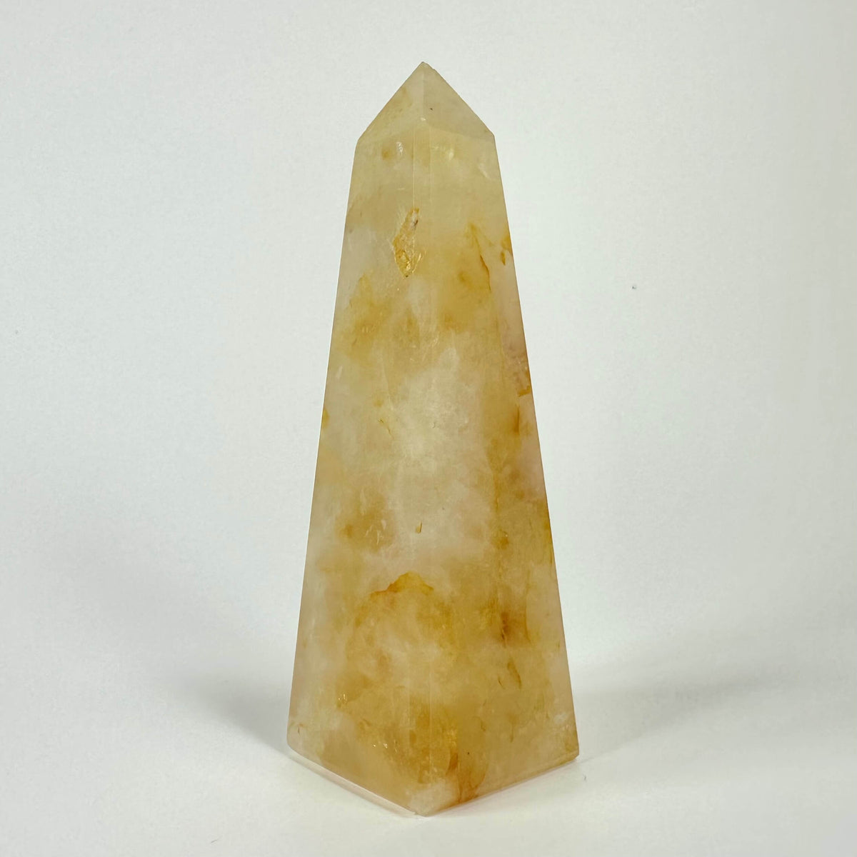 Golden healer obelisk mod hvid baggrund.