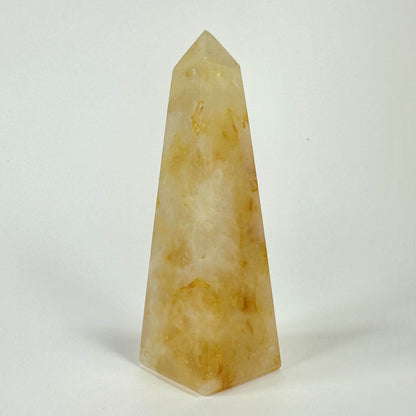 Golden healer obelisk mod hvid baggrund.