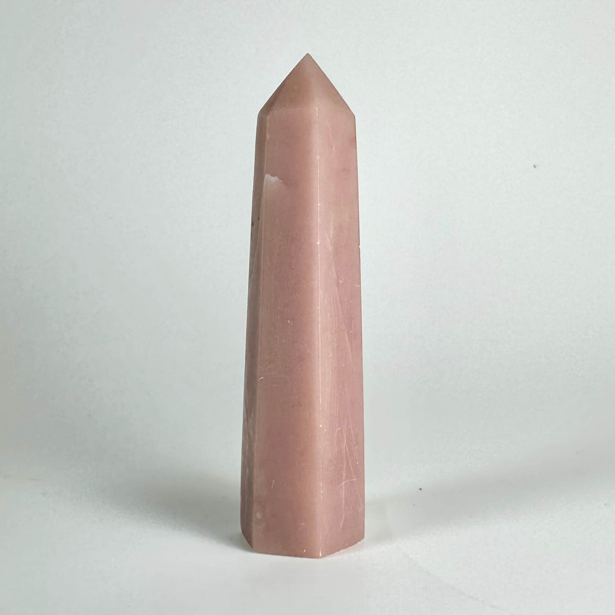 Pink opal tårn mod hvid baggrund.