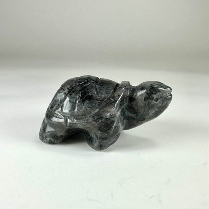 Larvikit skildpadde figurine på hvid baggrund, detaljeret med grå og sorte nuancer.