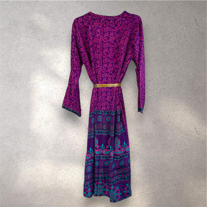 Lilla og blå blomstret kimono hænger på en grå væg.